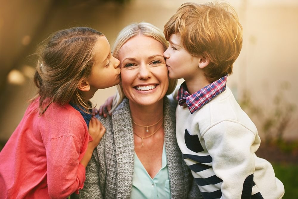 The Perfect Mother’s Day Gift: Swad Indian Kitchen. Mother, children, and a kiss with a smile in a portrait for Mother's Day, with family for love. Mom, kids and happiness with a single parent with child development in the backyard with hugs, together and siblings.